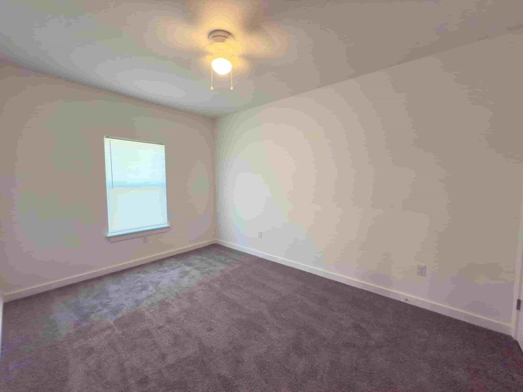 an empty room with white walls and a window