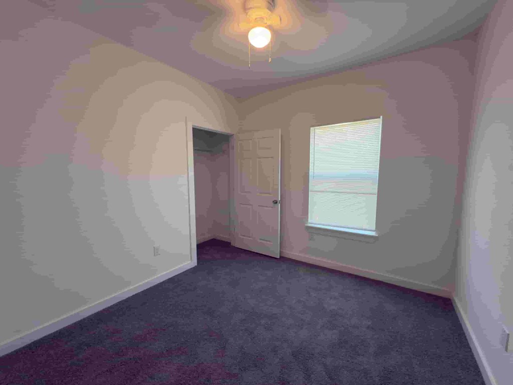 an empty room with a door and a window