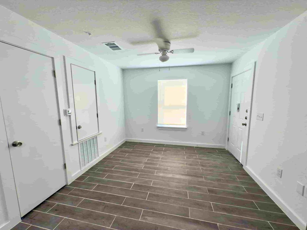 a room with a ceiling fan and a tile floor