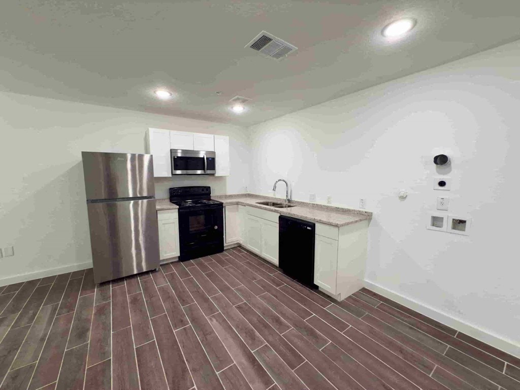 a kitchen with a refrigerator and a stove and a sink