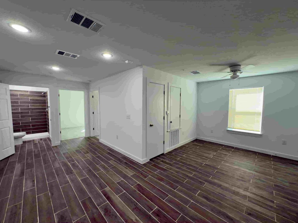 a living room with a hard wood floor and a ceiling fan