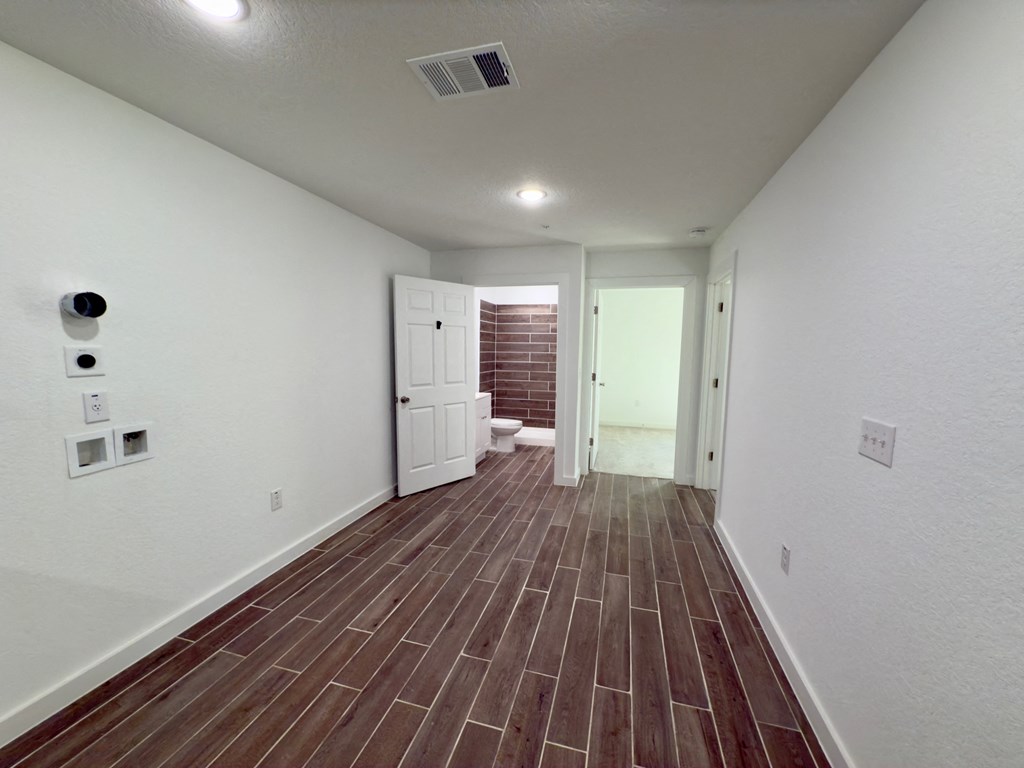 the living room and entrance to the bathroom of a new home