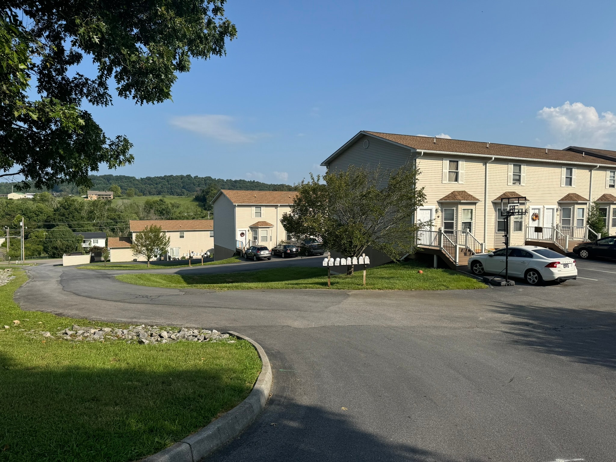 A white car is parked in front of a house.