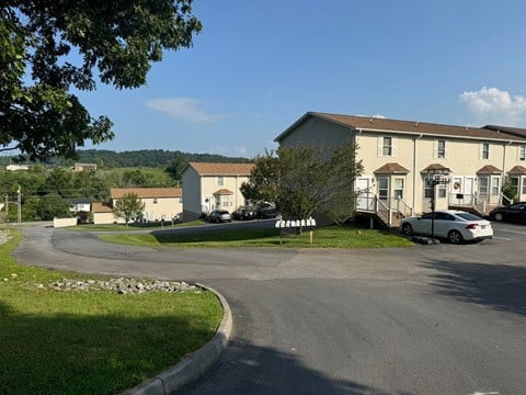 A white car is parked in front of a house.