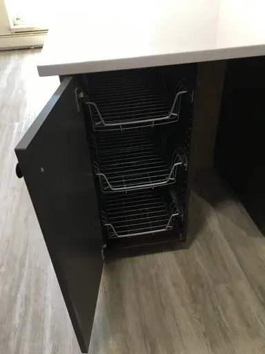 A black oven with three racks is built into a kitchen counter.