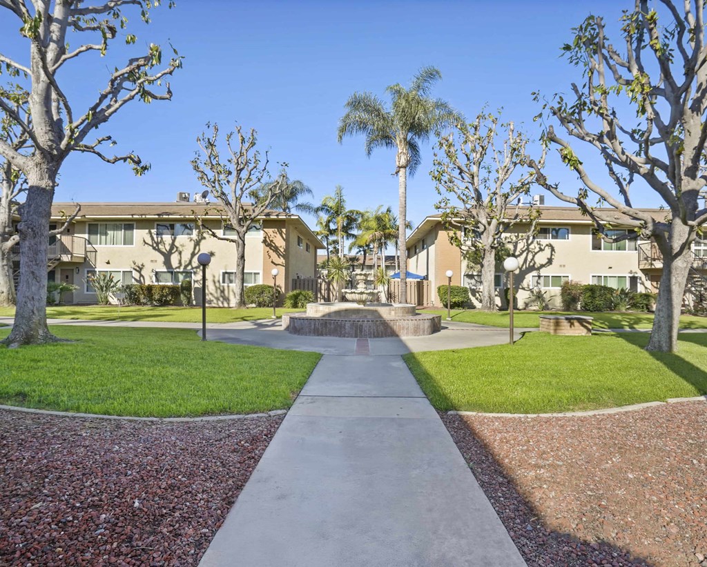 A pathway leads through a landscaped area with trees and shrubs.