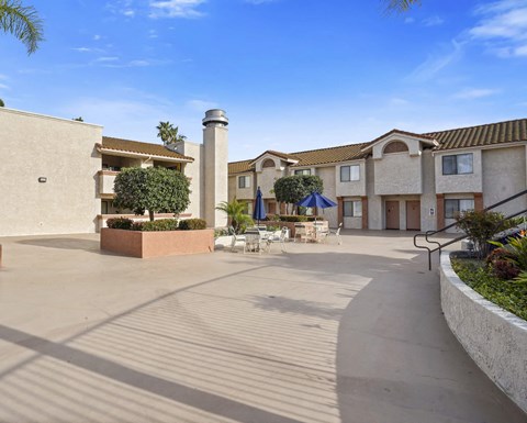 A courtyard with a building and a tree in the middle.