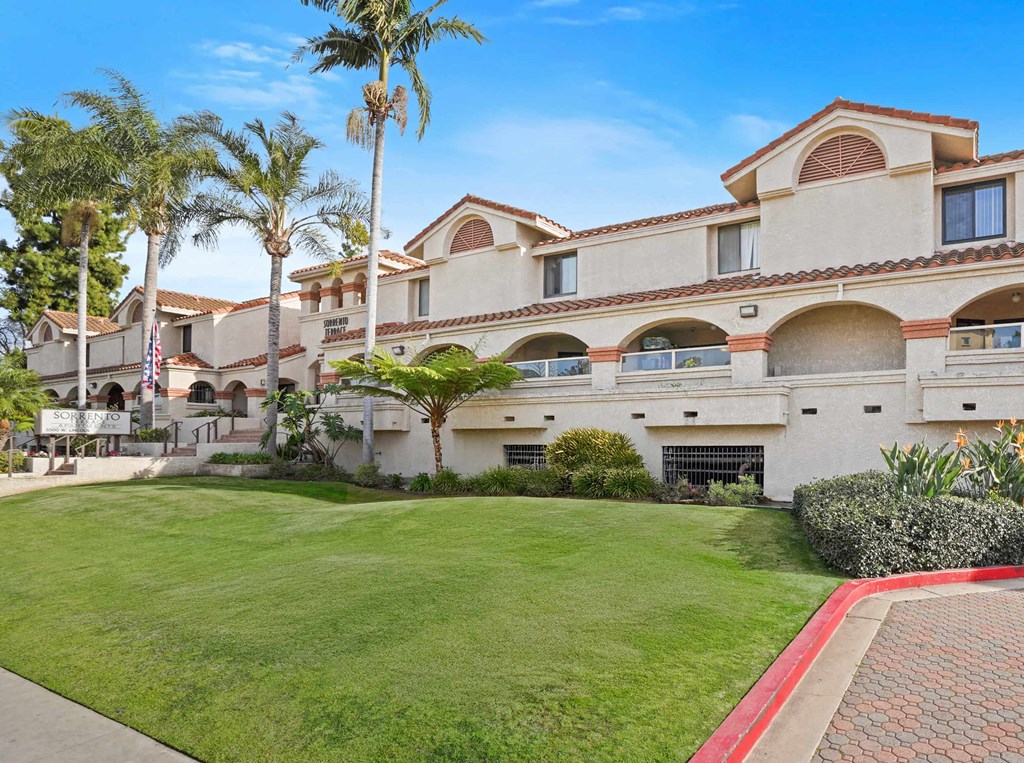 A large building with a red brick walkway in front of it.
