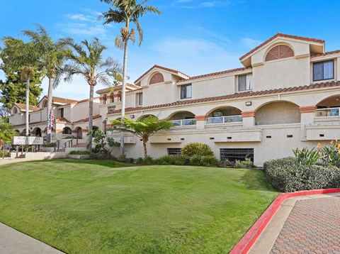 A large building with a red brick walkway in front of it.