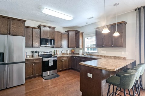 a kitchen with a large island and a stainless steel refrigerator