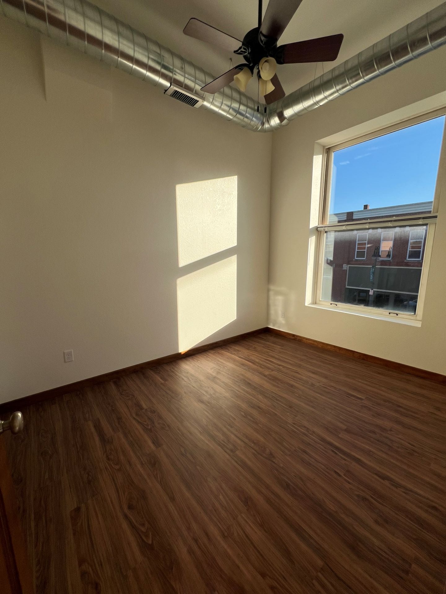 A room with a ceiling fan and a window.