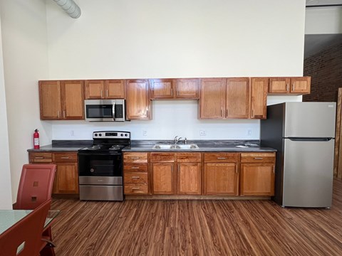A kitchen with wooden cabinets and a black counter top.