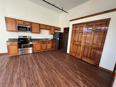 A kitchen with wooden floors and a wooden door.