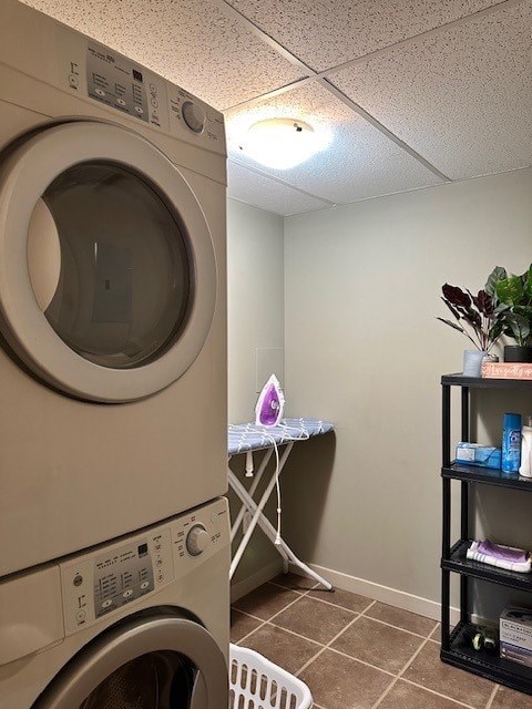 A washing machine sits in a laundry room with a shelf and ironing board.