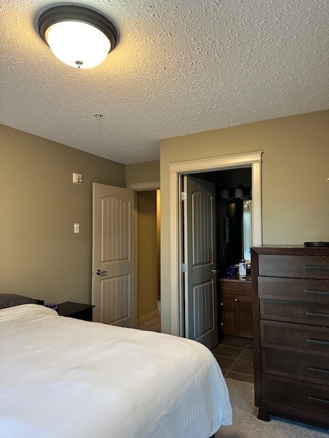 A bedroom with a bed, dresser, and mirror.
