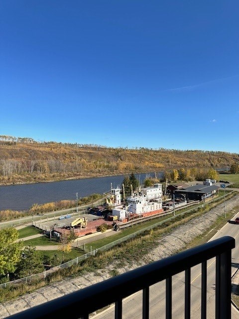 A view of a river with a bridge and a building in the distance from a balcony.