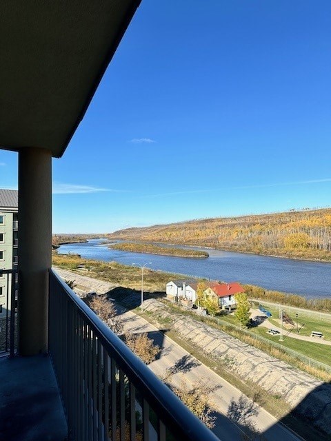A river flows through a valley with houses on the side.