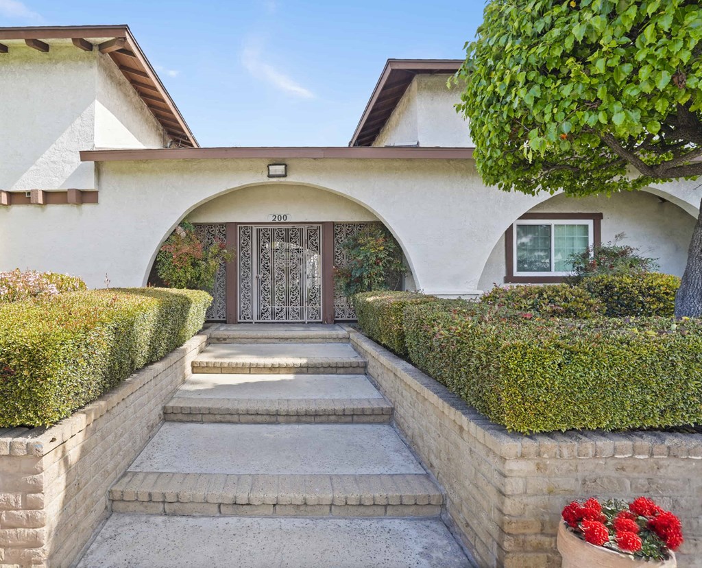 A house numbered 200 with a front yard and steps leading to a door.