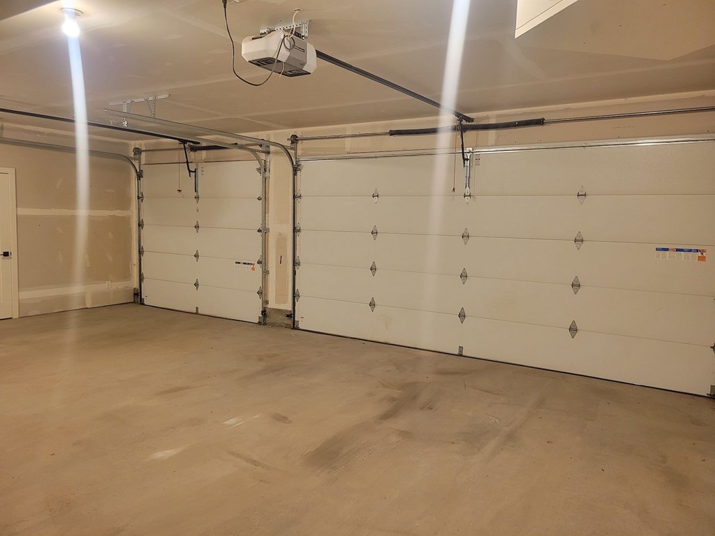 A garage with a white wall and a white door.