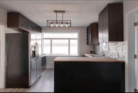 A modern kitchen with dark wood cabinets and a large island.