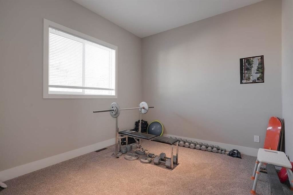 A room with a weightlifting set up and a picture on the wall.