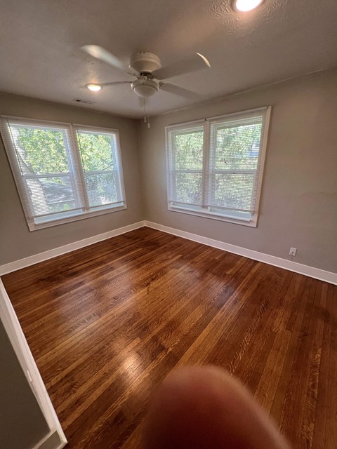 a living room with wood floors and a ceiling fan