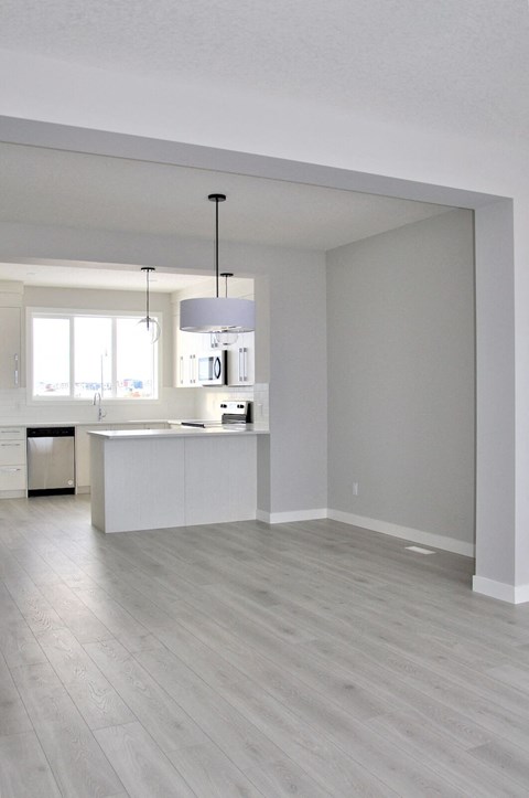 A kitchen with a white counter and a grey floor.