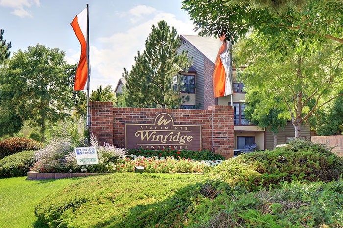 the sign for the winfield estate with flags in front of the building