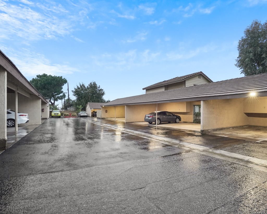 A parking lot with cars and a building in the background.