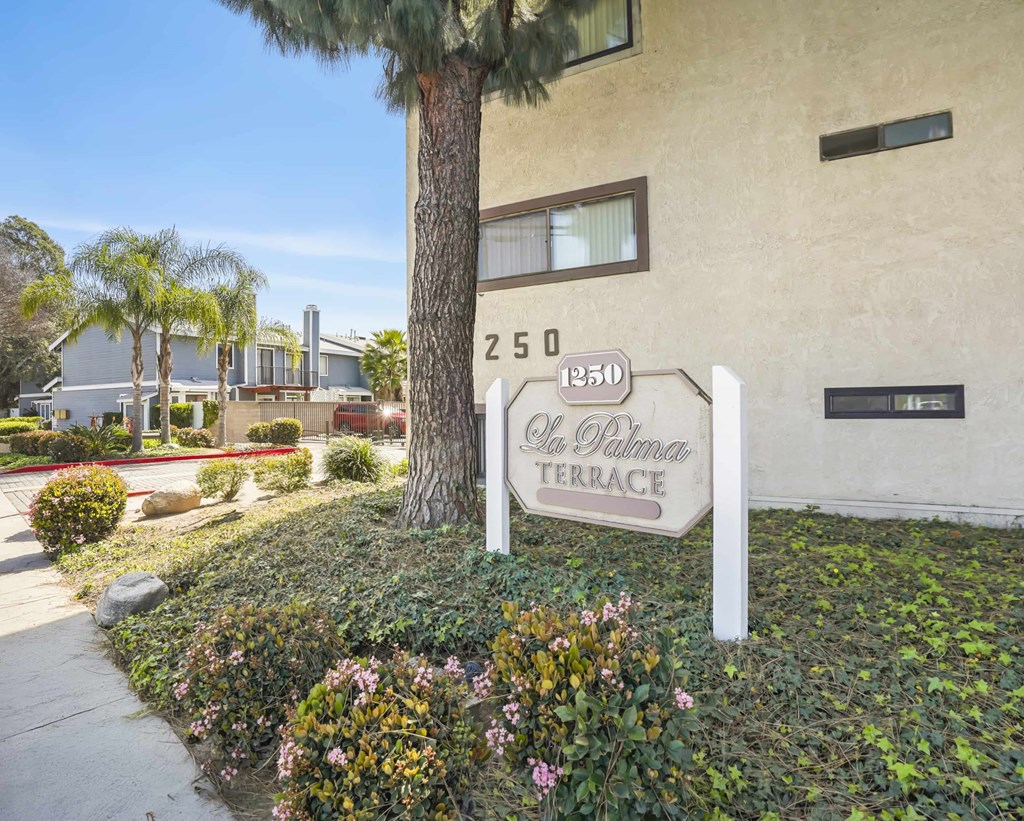 A sign for "El Palomar Terrace" is displayed in front of a building.