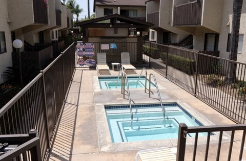 A small pool with a slide in the middle of a patio.