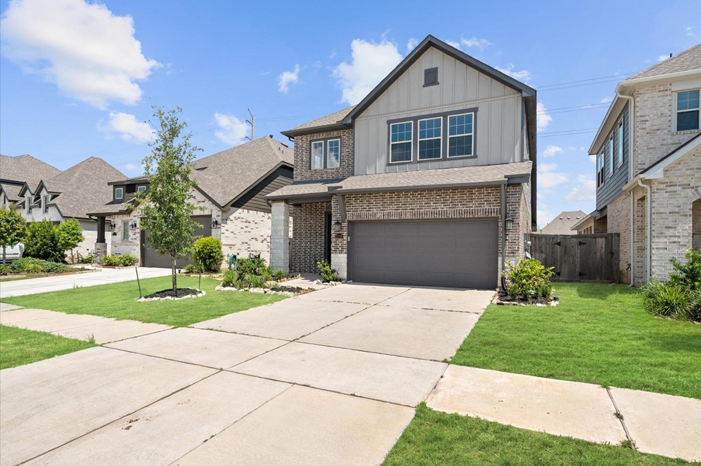 A house with a garage and a driveway in front of it.