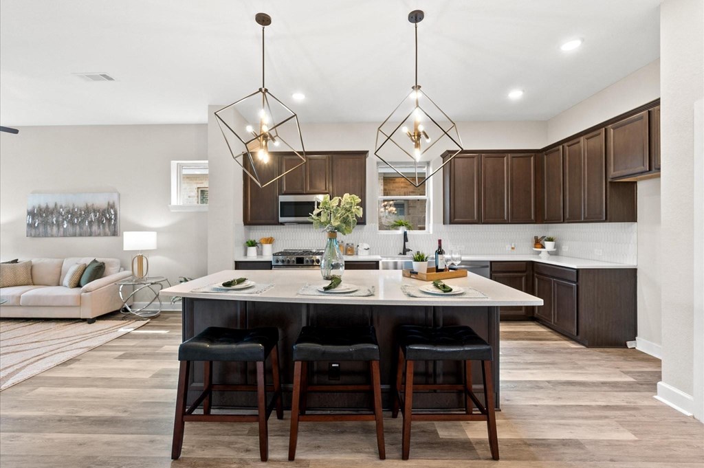 A modern kitchen with a large island and bar stools.