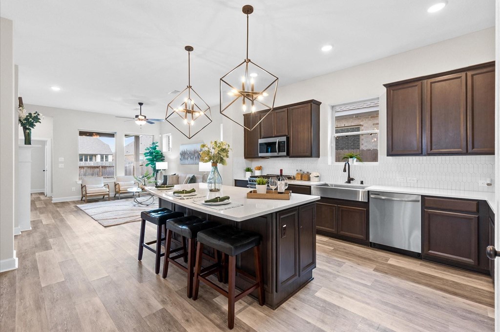 A kitchen with a large island and bar stools.