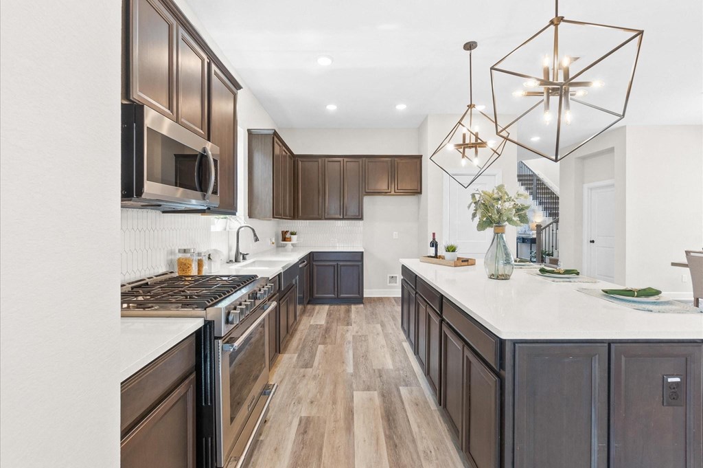 A modern kitchen with dark wood cabinets and a white countertop.