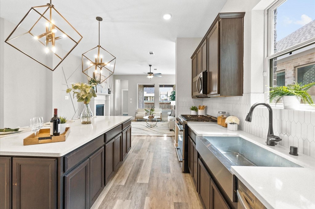 A modern kitchen with dark wood cabinets and a white countertop.