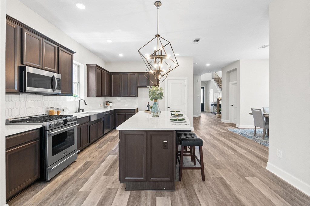 A modern kitchen with dark wood cabinets and a white island.
