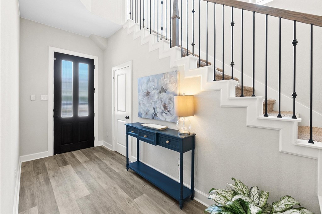 A staircase with a black railing and a light on the side.