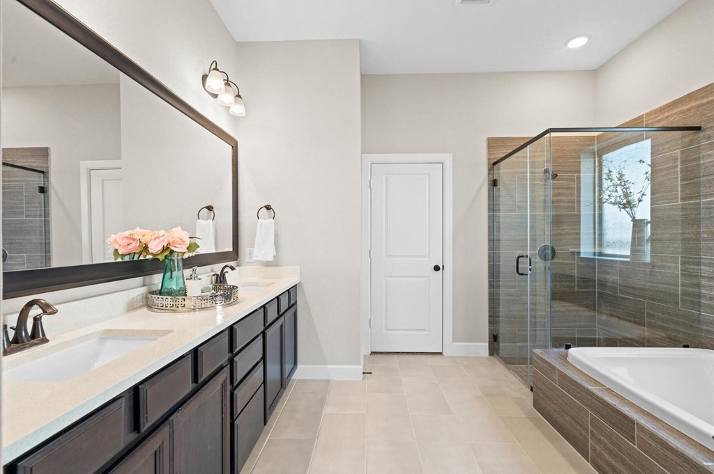 A bathroom with a white door, a sink, a mirror, and a bathtub.