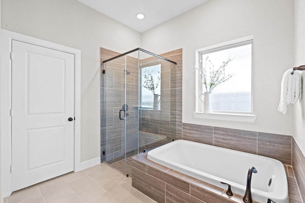 A white door is on the left of a tiled shower area.