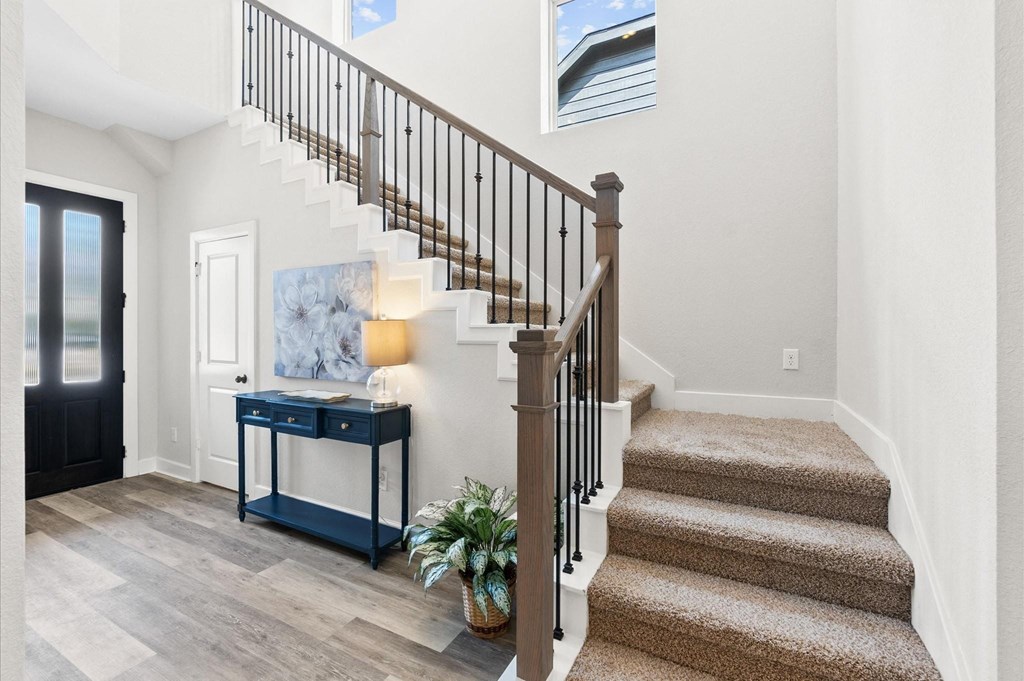 A staircase with a light on the side table.