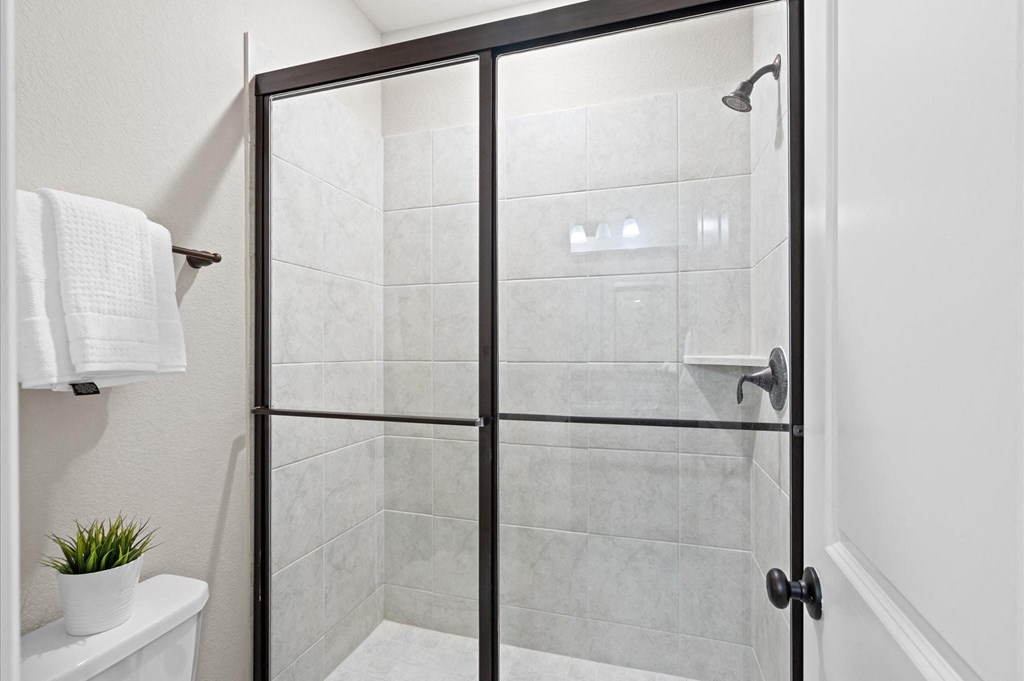 A white towel hangs on a towel rack in a bathroom.