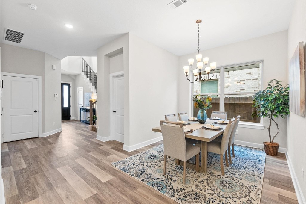 A dining room with a table set for four.