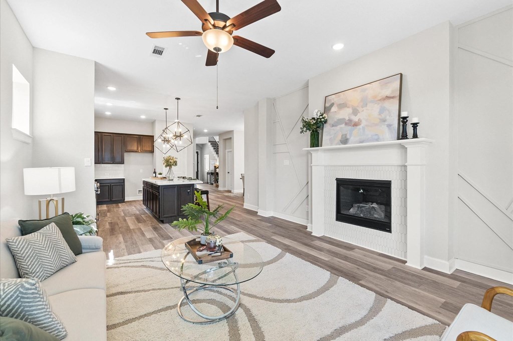 A living room with a fireplace and a ceiling fan.