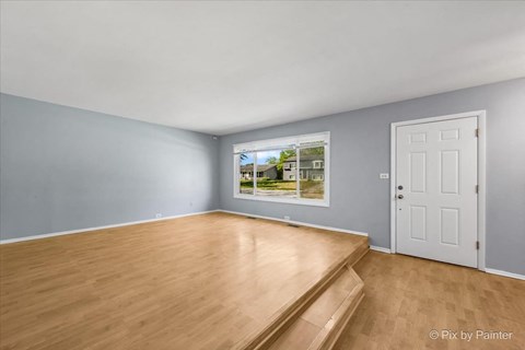 a living room with wood flooring and a window