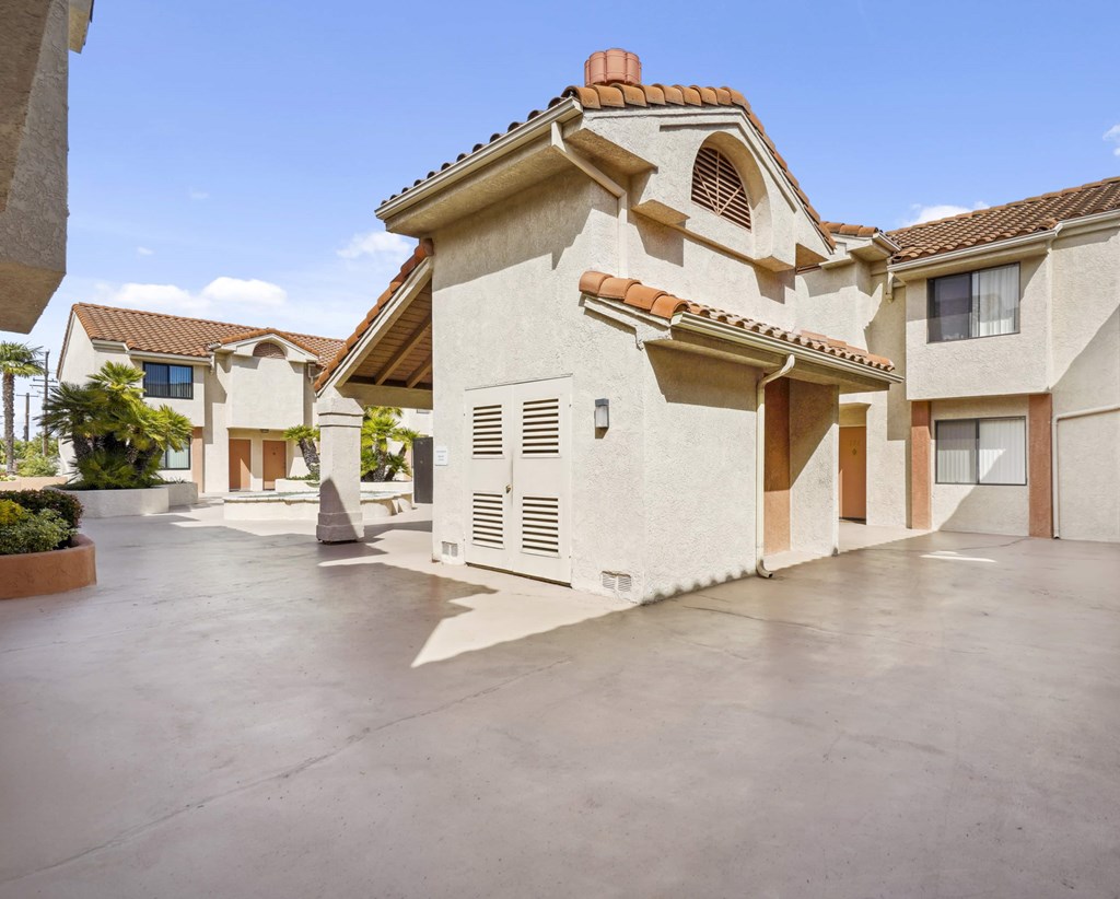 A modern house with a large driveway and a clear blue sky.