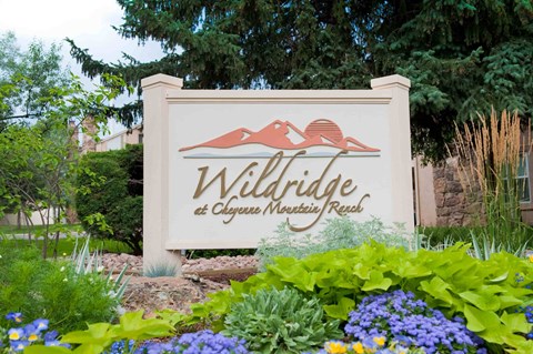 A sign for Wildridge at Clyde's Mountain Ranch is surrounded by flowers.