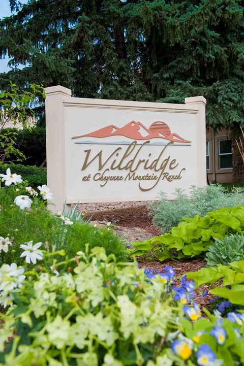 A sign for Willridge at Chayser Mountain Reel sits in front of a garden.