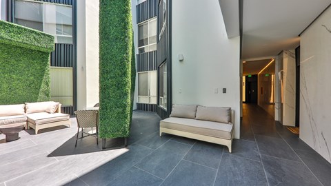 a living area with a couch and chairs and a green wall