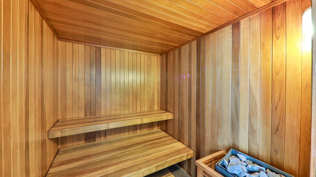 a sauna with wooden walls and a basket of rocks